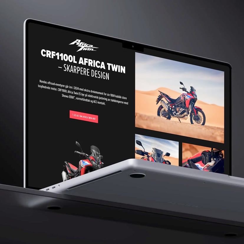 A laptop screen displays a website built on a scalable ecommerce platform, featuring the Honda CRF1100L Africa Twin motorcycle with images of the bike in a desert and text about its design and features.